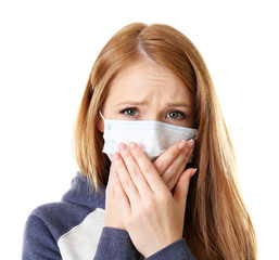 Red-haired girl with a medical mask on a white background