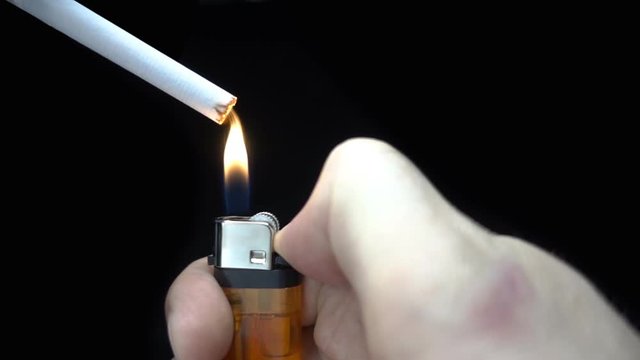 Man ignite the lighter and light a cigarette and blew smoke. Closeup. Slow motion, high speed camera, 250fps
