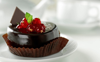 Chocolate cake with fresh currant on light background