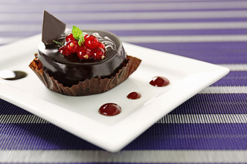 Chocolate cake with fresh currant on table
