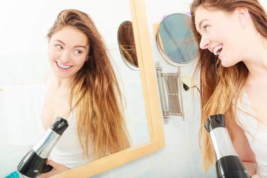 long haired woman drying hair in bathroom