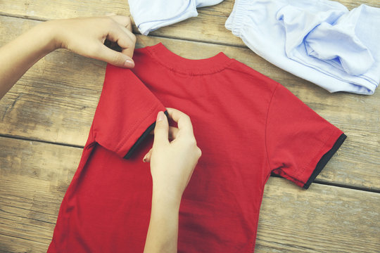 Woman Folding Baby Clothes