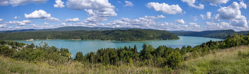 Fototapeta na wymiar Panorama d'un lac aux eaux turquoises dans le Jura , lac du Vouglan