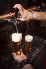 Fototapeta na wymiar The bartender pours a beer in glass v1