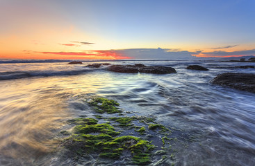 Naklejka premium Waves & Mossy of Tanah Lot beach at sunset in bali indonesia for background