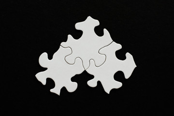 Three blank puzzle pieces on black background
