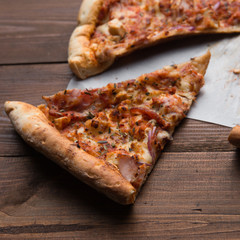 slice of pizza on a wooden background