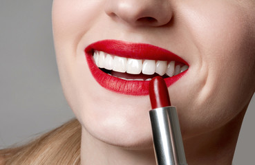Naklejka premium Beauty portrait applying red lipstick on lips perfect make up.