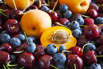 Naklejka na ściany i meble Summer berries and fruits: sweet cherries, blueberries and apricot