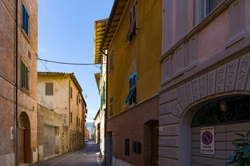 Fototapeta na wymiar Narrow European town street with sea view. No Parking sign in Italian. Orbetello, Italy