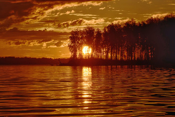 Naklejka na ściany i meble Landscape setting sun on the background of the river.
