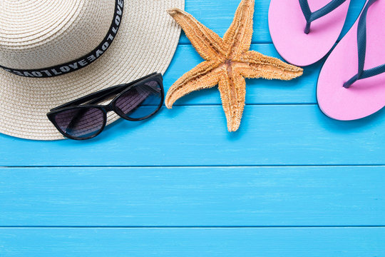 Straw hat and sunglasses on wood