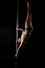 Pole dance. Photo of strong guy posing at camera