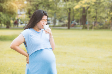 Pregnant woman drinking organic milk with a copy space. (Vintage tone)