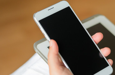 smartphone with white black screen display on hand, brown backgr