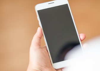 smartphone with white black screen display on hand, brown backgr