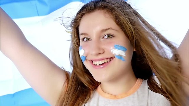 Girl waving Argentinian flag and smiling, slow motion
