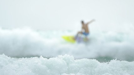 Naklejka premium Defocus surfer enjoys the waves