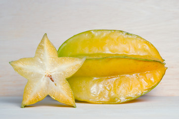 Star apple fruit with half cross section isolated on wooden boar