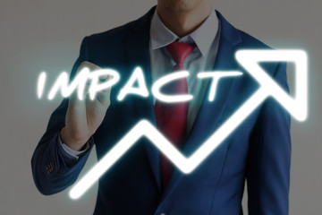 Businessman drawing IMPACT and upward graph arrows forward