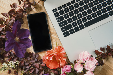 Creative workspace with beautiful flowers and mobile technology.