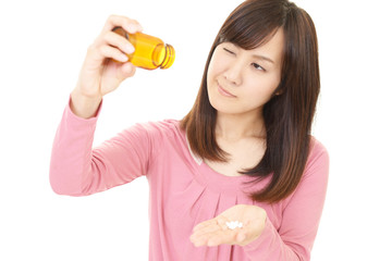 サプリメントを飲む女性