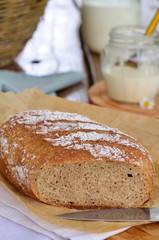 Homemade bread, milk, cream on a wooden background