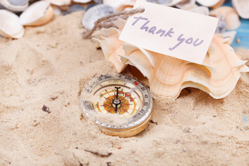 Fototapeta na wymiar Compass in the sand with Message - Thank you