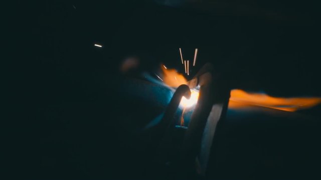 Welding works on a black background and a lot of sparks. Slow motion, high speed camera, 250fps