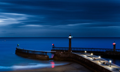 WHITBY, ENGLAND - JULY 16: The West Lighthouse and pier, at night. Long exposure. In Whitby, North Yorkshire, England. On 16th July 2016.