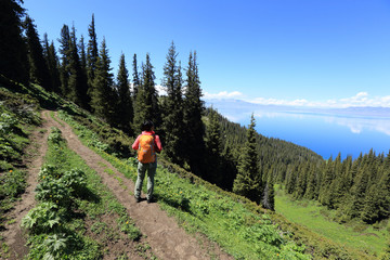 young woman backpacker hiking on beautiful mountain peak trail