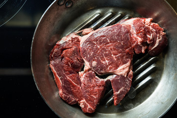 Fresh steak on marble background. Uncooked beefsteak cooking on a kitchen. Delicious, spicy, juicy meat with copy space closeup.