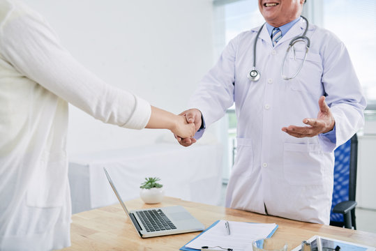 Cropped image of doctor and patient shaking hands