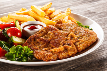 Fried pork chop, French fries and vegetable salad 