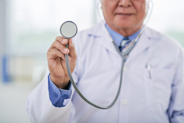 Cropped image of doctor holding stethoscope in front of him