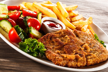 Fried pork chop, French fries and vegetable salad 