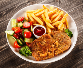 Fried pork chop, French fries and vegetable salad 