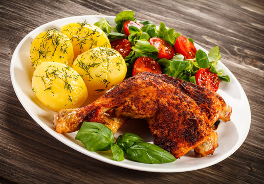Roast chicken legs with boiled potatoes and vegetables 