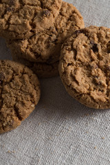 Cookies pile with chocolate chip on light textile background. Delicious morning snacks for breakfast, brunch and lunch. Appetizing, healthy, sweet, scrummy, and fast food.