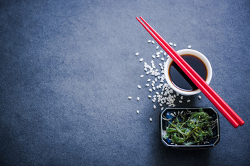 soy sauce , chopsticks and seaweed salad