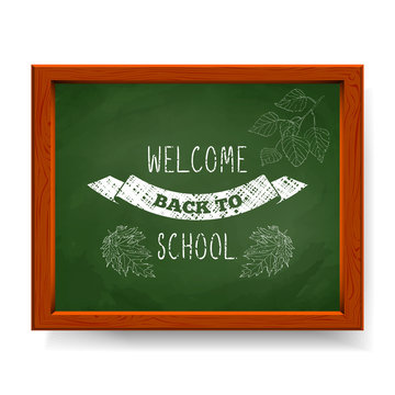 Welcome back to school text written in chalk on green blackboard