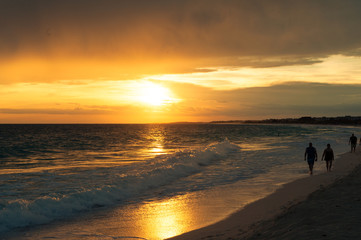 Sonnenuntergang am Meer. Paar geht am Strand spazieren.