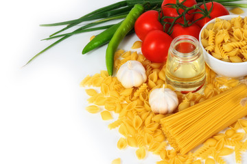 Different types of raw Italian pasta with tomatoes and other vegetables. Top view background. Copy space