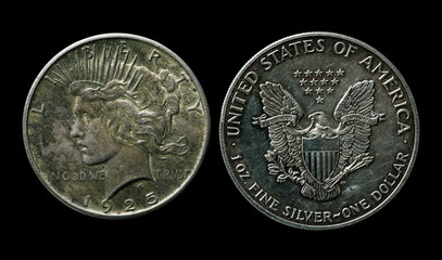 Two silver american dollars isolated on black