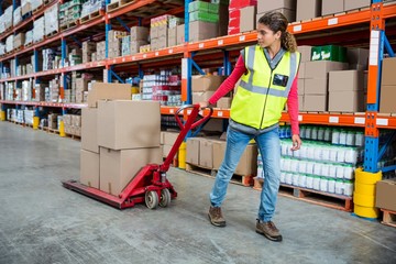 Worker pushing trolley with boxes