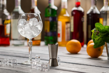 Bar jigger and wineglass. Glass full of ice cubes. Order whatever you want. Bartender's workplace in restaurant.