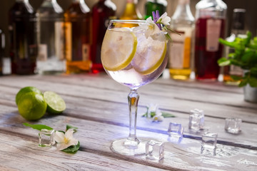 Cocktail with lemon in glass. White flowers and ice cubes. Tom collins served at nightclub. Alcoholic beverage with best gin.