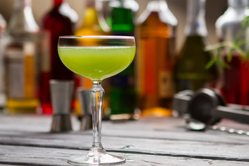 Green beverage in glass. Coupe glass with colorful liquid. Bartender's recipe of kiwi daiquiri....