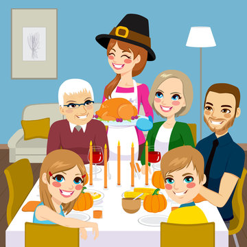 Happy family having thanksgiving dinner together with mom serving traditional roasted turkey