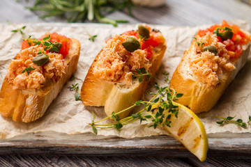 Toasts with fish meat. Green herb and capers. Freshly cooked bruschetta with salmon. Great food from organic ingredients.
